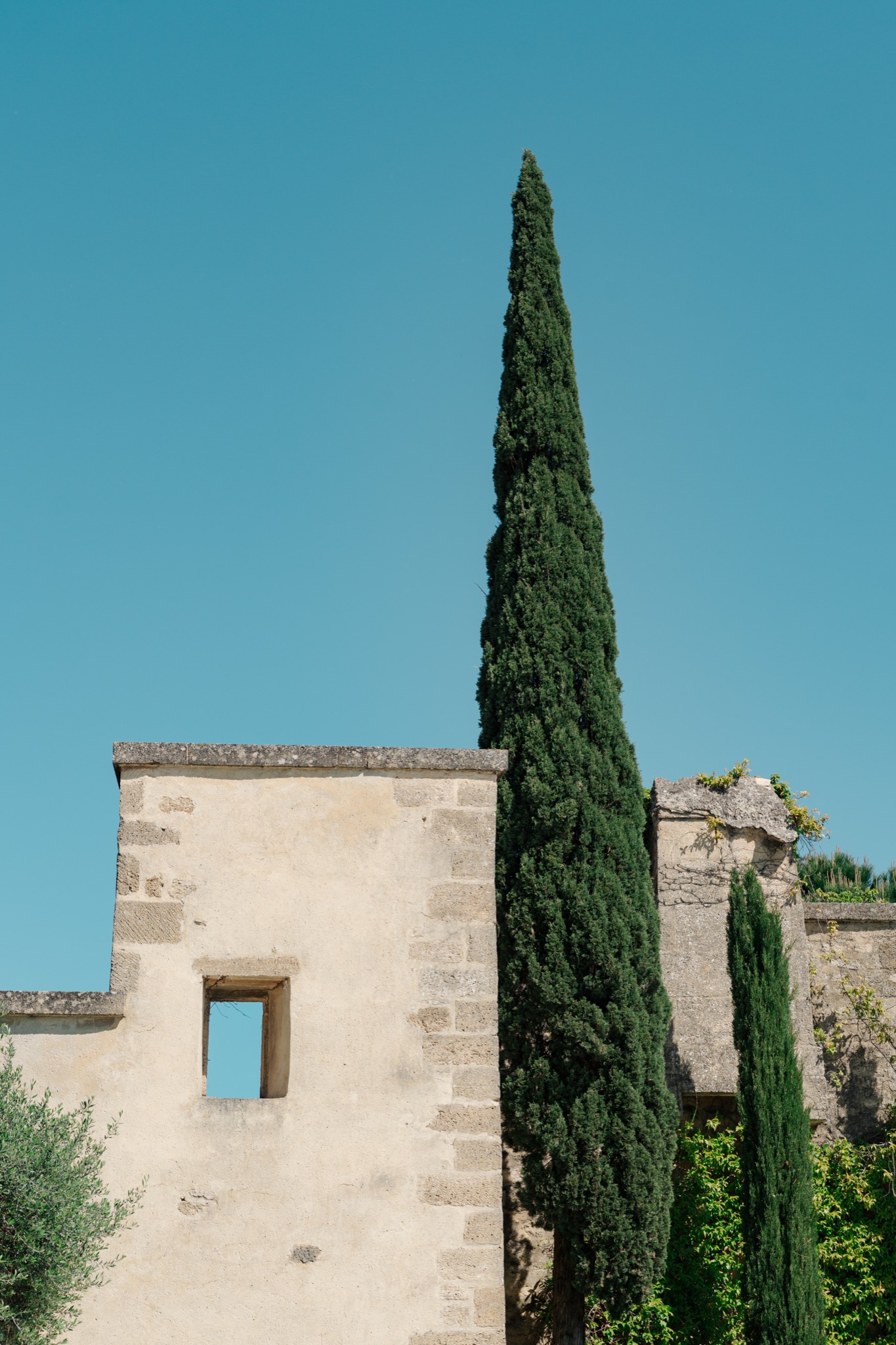 A stone villa framed by cypress trees under an evening sky